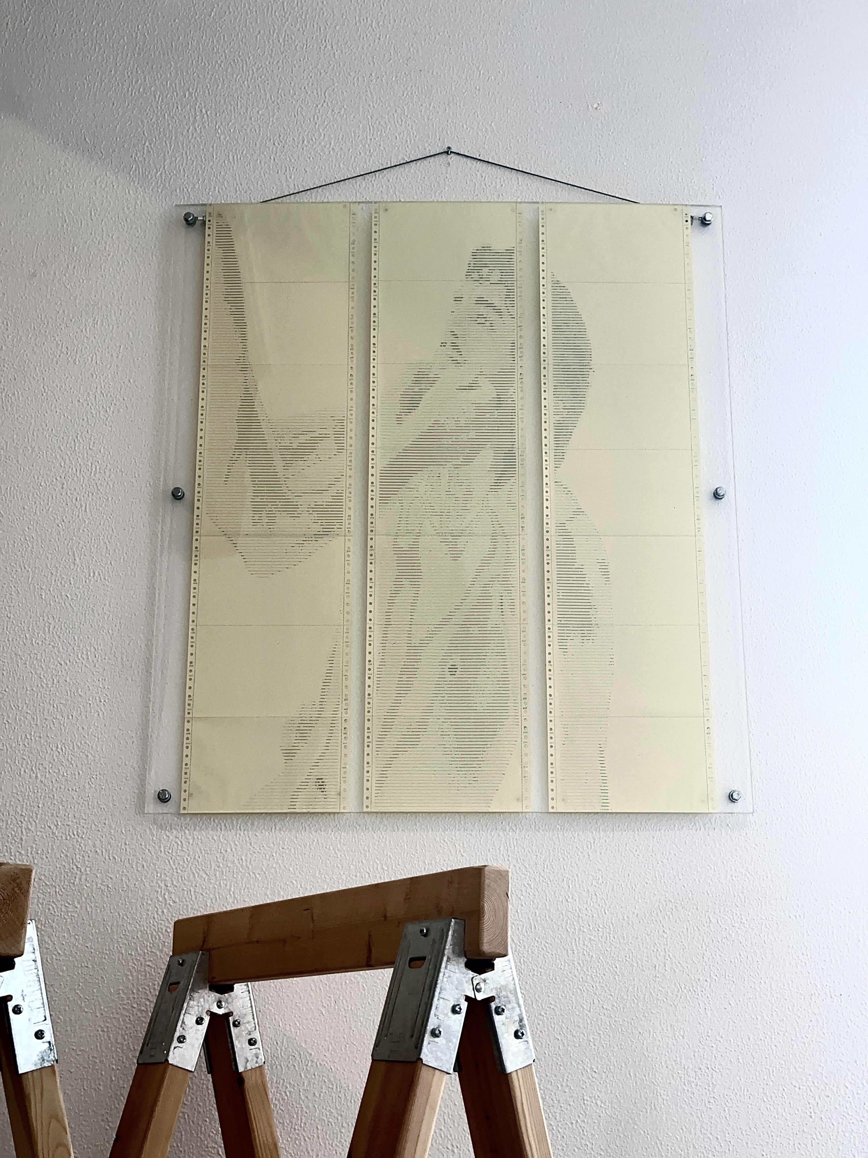 AWAITING INPUT by CHARACTERS shown with nearby objects for scale — three-sheet ASCII scroll, 72 × 97 cm, dot-matrix print on deadstock continuous-feed paper. Source photograph by Oli Raptor. 2024.