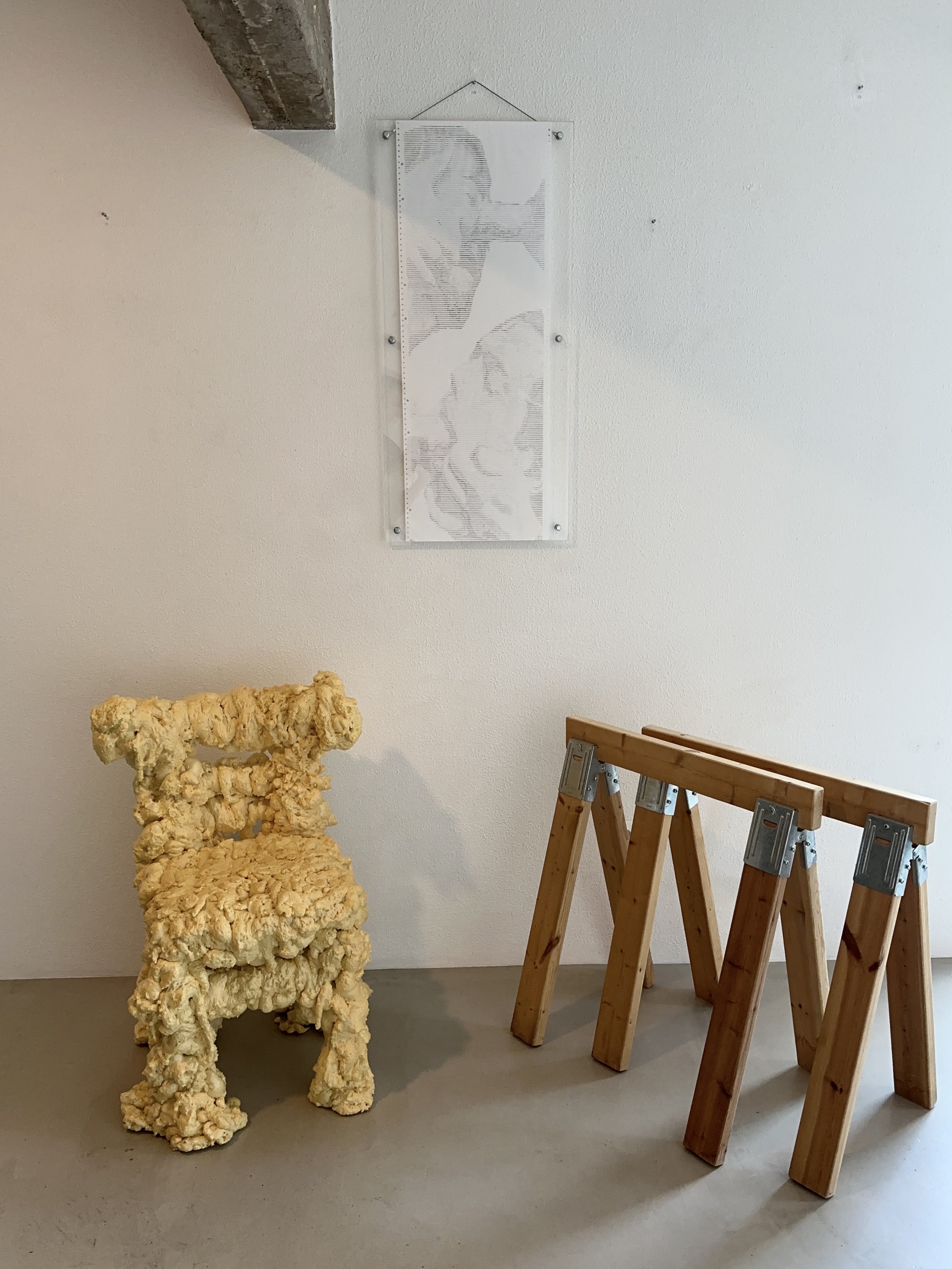 INPUT.OVERRIDE by CHARACTERS shown with nearby furniture for scale — single-sheet ASCII scroll, 38 × 102 cm, the origin work of the practice. 2022.