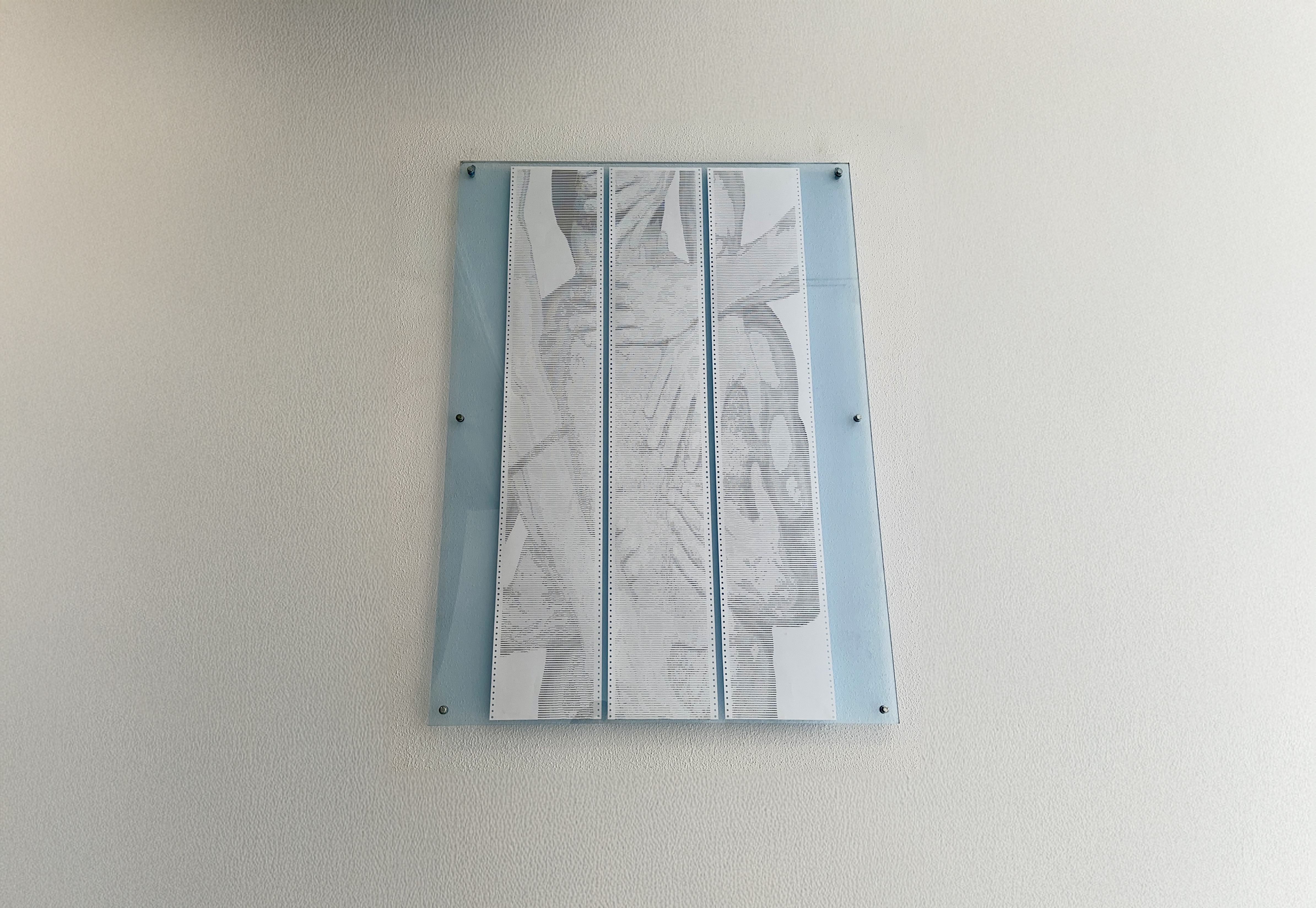 SOFT.RENDER by CHARACTERS — three-sheet ASCII scroll, 72 × 140 cm, framed and installed on wall. Dot-matrix impact print on deadstock continuous-feed paper, 2025.